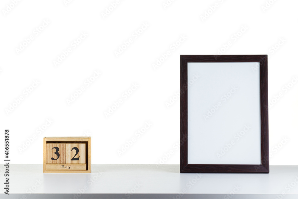Wooden calendar 32 may with frame for photo on white table and background Wooden calendar 32 may with frame for photo on white table and background