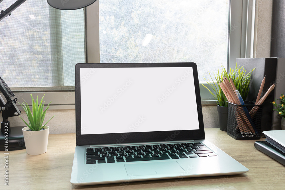 Laptop computer with white blank screen on desk in workspace and copy space concept Laptop computer with white blank screen on desk in workspace and copy space concept