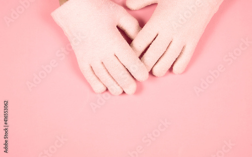Spa gel moisturizing gloves on pink background with copy space for design. Skin care and beauty routine concept.