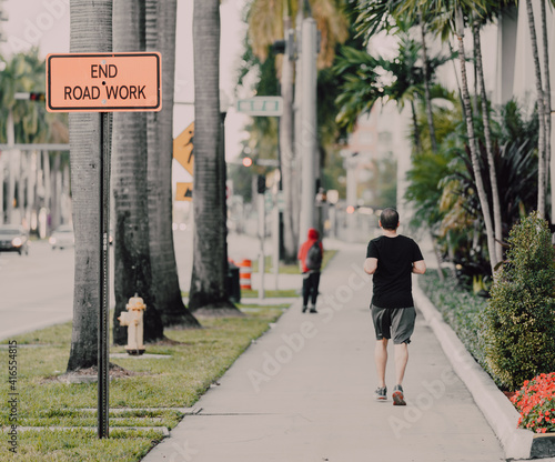 Wallpaper Mural person walking in the city man sidewalk palms trees Torontodigital.ca