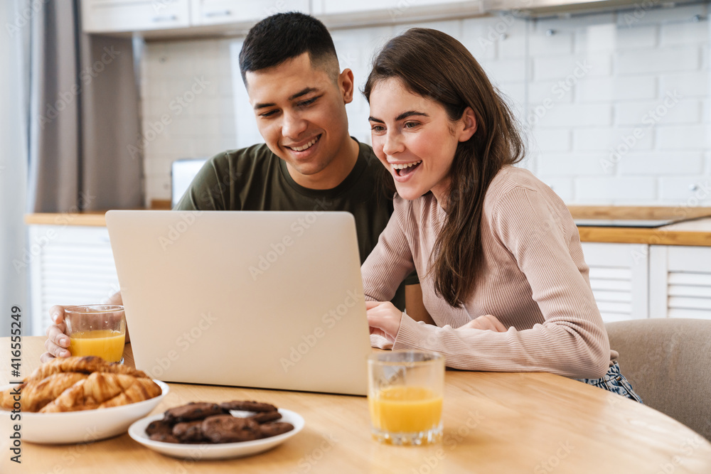 Smiling happy couple enjoying breakfast in the kitchen Smiling happy couple enjoying breakfast in the kitchen