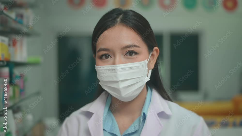 Portrait of asian woman pharmacist wearing a surgical mask in a modern pharmacy drugstore, covid-19 and pandemic concept. Portrait of asian woman pharmacist wearing a surgical mask in a modern pharmacy drugstore, covid-19 and pandemic concept.