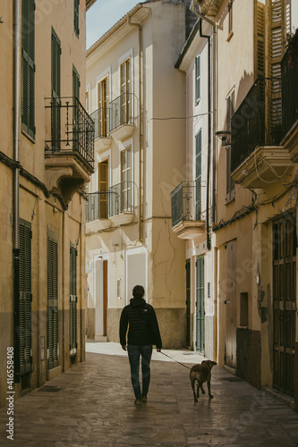 Girl walking her dog in a village in majorca