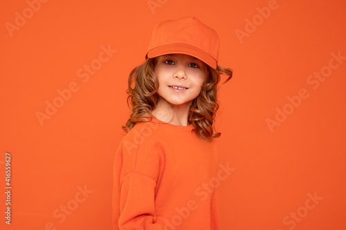 Beautiful child girl 6-7 years old in orange cap with place for text, mock up. Studio shot, Printing on textiles, production of hats © Татьяна Волкова