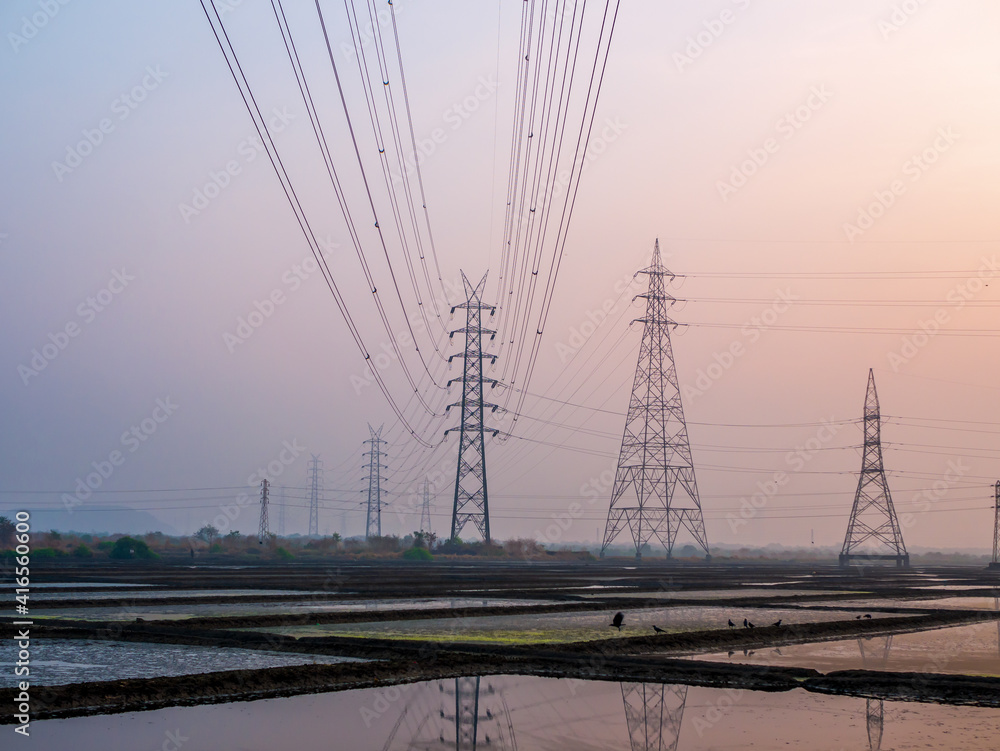 Reflection of High-voltage power lines in Sea salt farm and barn