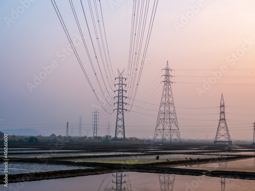 Reflection of High-voltage power lines in Sea salt farm and barn