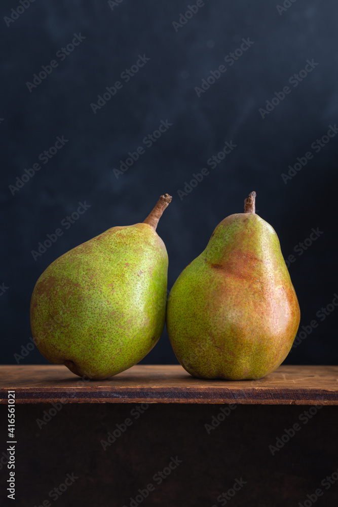 Two beautiful pears on wood and a black background, copy space Two beautiful pears on wood and a black background, copy space