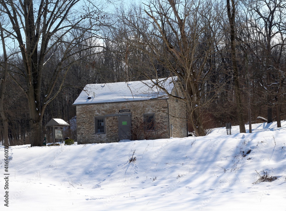 The old stone building in the snowy park landscape.