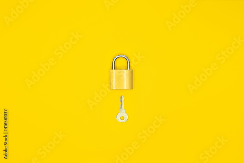 Lock and key on a yellow background.