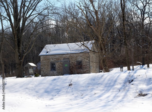 The old stone building in the snowy park landscape. © Al