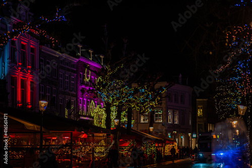 Christmas city lights cozy street cafe scene. Beautiful sparkling and twinkling lights on a European Christmas Market. Winter holiday season.