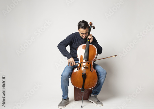 Photographie young man playing cello on the white background