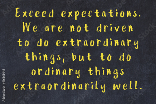 Foto Chalk inscription of smart quote on black desk