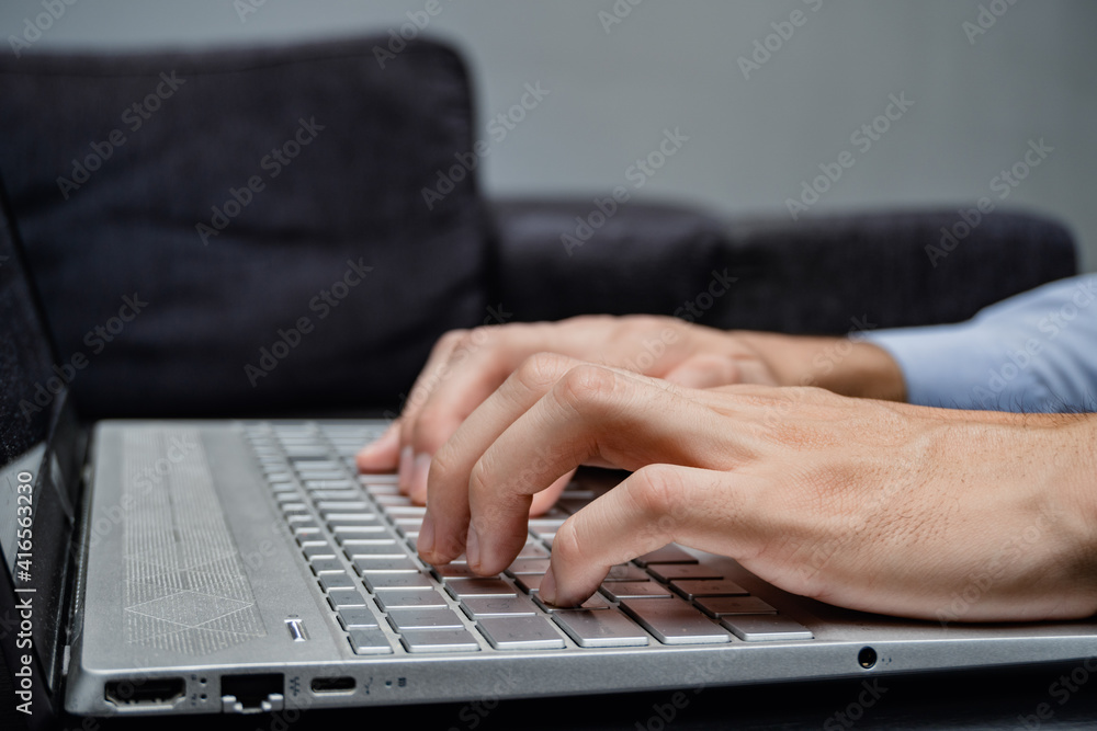 a man typing on his laptop all gray and modern a man typing on his laptop all gray and modern