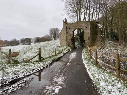 WINCHELSEA, EAST SUSSEX, UK - JULY 12th 2020 : The New Land gate entrance arch to Winchelsea in East Sussex, dating from 1300 part of old wall in snow © cheekylorns