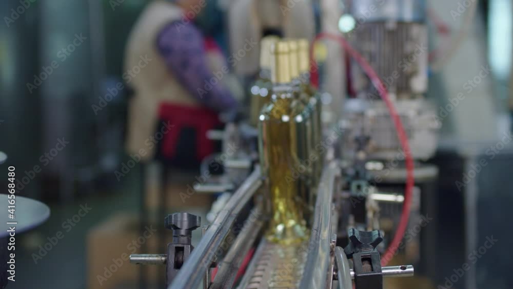 Wine production factory. Glass bottles filled up with white wine Bottling production line. Wine production factory. Glass bottles filled up with white wine Bottling production line.
