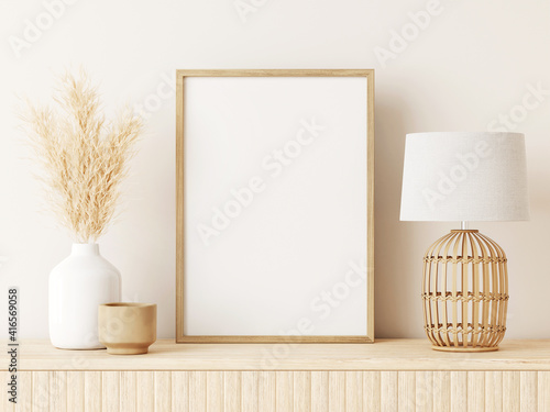 Vertical poster art mockup with beige wooden frame, dried grass in vase, wicker basket lamp on empty warm white background. Japandi interior decoration. A4, A3 format. 3d rendering, illustration
