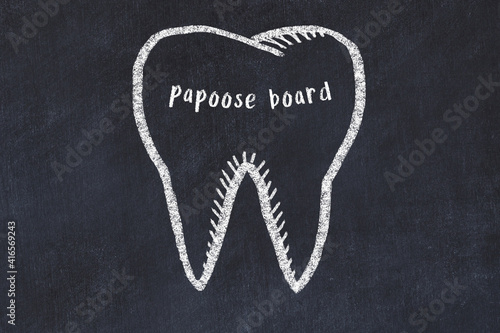 Chalk drawing of a tooth with medical term papoose board. Concept of learning stomatology
