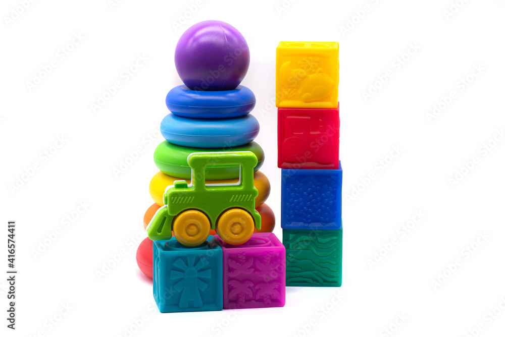 Children's multi-colored pyramid, plastic steam train and rubber cubes on a white background Children's multi-colored pyramid, plastic steam train and rubber cubes on a white background