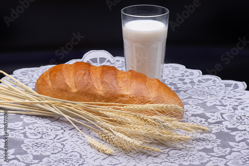 Obraz na płótnie Composition of glass of milk, wheat, white bread on a white tablecloth w salonie