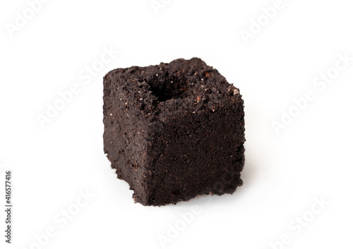 Single soil block made with soil blocker. Eco-friendly method to compress potting soil to blocks. Used for early indoor seed starting without trays. Vegetable gardening concept. Selective focus. © Petra Richli