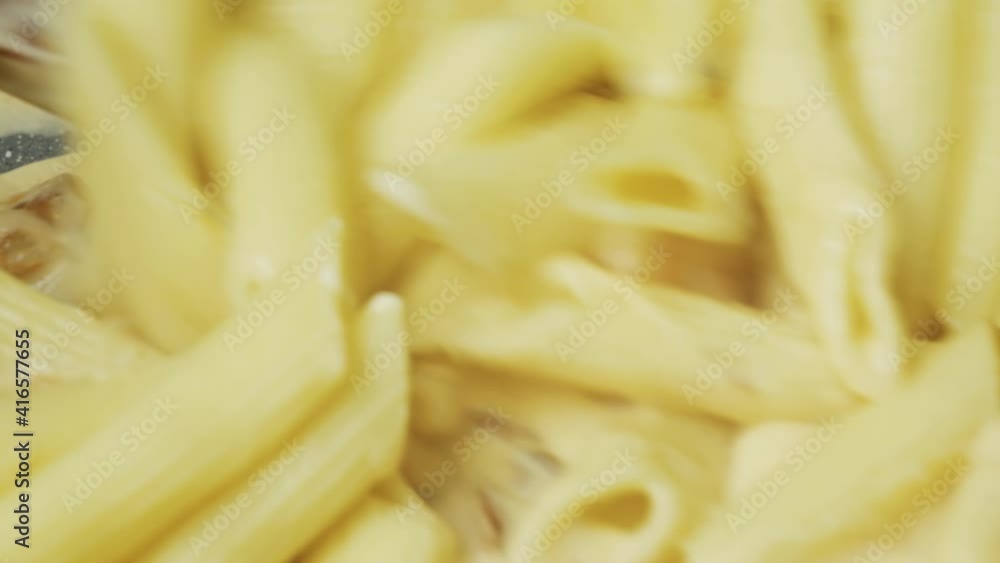 Shrimps are fried in a pan in sauce, with pasta, stirring with a spoon, close-up Shrimps are fried in a pan in sauce, with pasta, stirring with a spoon, close-up