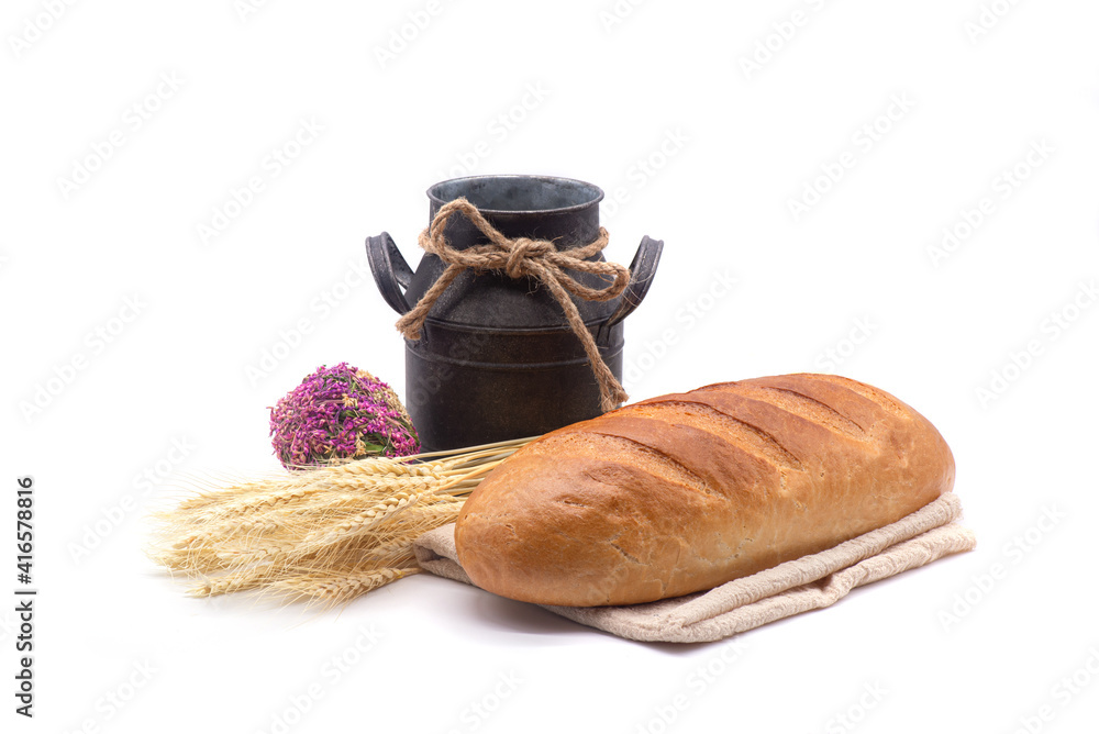 Composition of white bread, wheat, antique jug, kitchen towel and dried flowers on white background