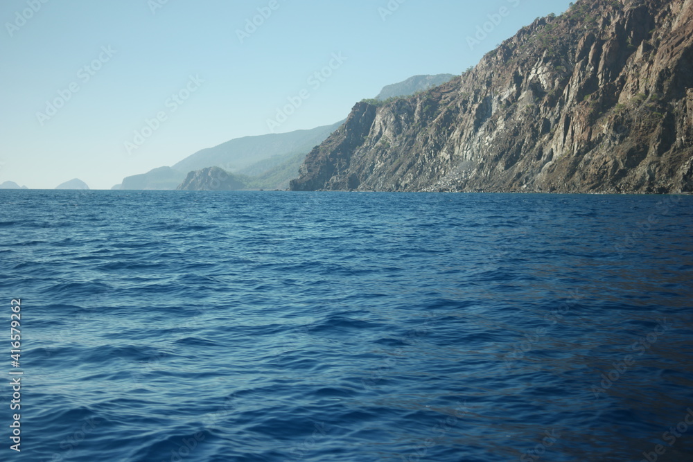 Calm blue sea, mountains and sky. A seascape with mountains at Turkey. Picturesque marine scenery. Calm blue sea, mountains and sky. A seascape with mountains at Turkey. Picturesque marine scenery.