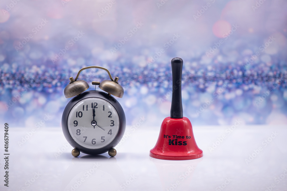 Retro alarm clock and red bell with inscription It's time to kiss on a festive background