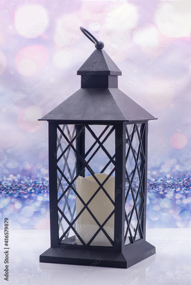 Glass lamp with a candle inside on a festive background