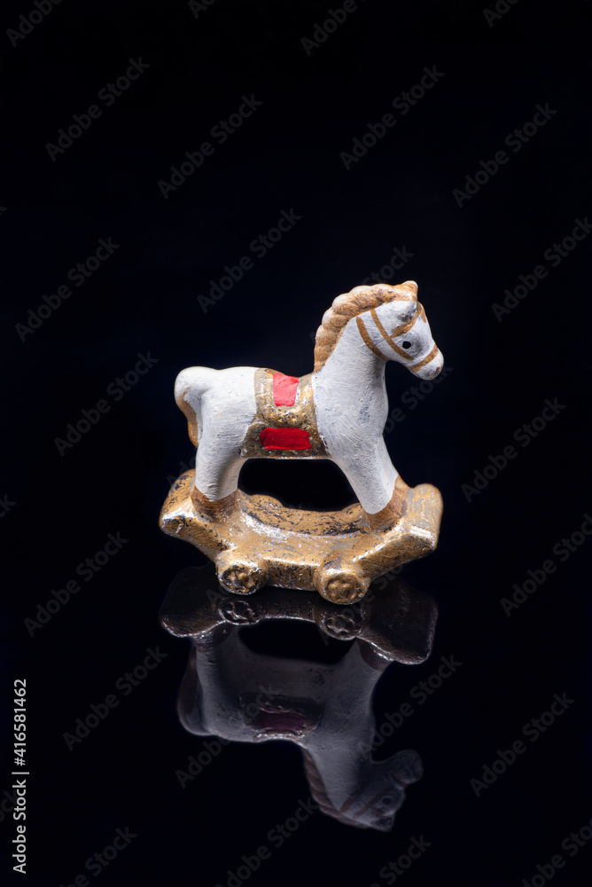 Toy clay horse on black background