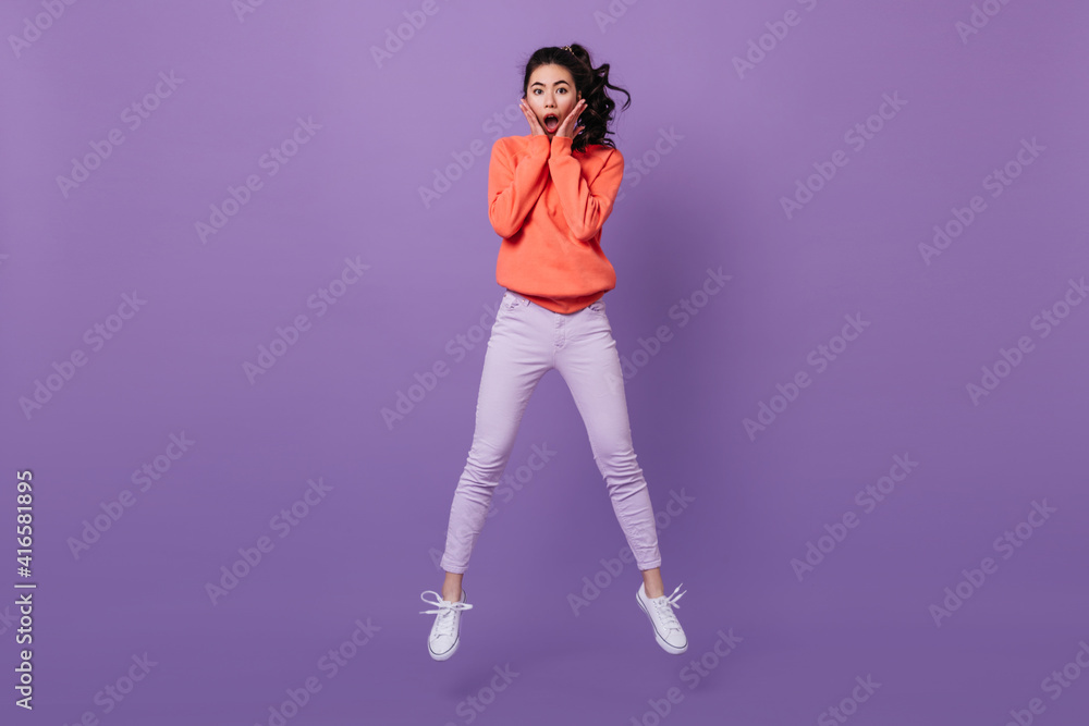 Amazed asian woman looking at camera. Studio shot of jumping surprised chinese girl. Amazed asian woman looking at camera. Studio shot of jumping surprised chinese girl.