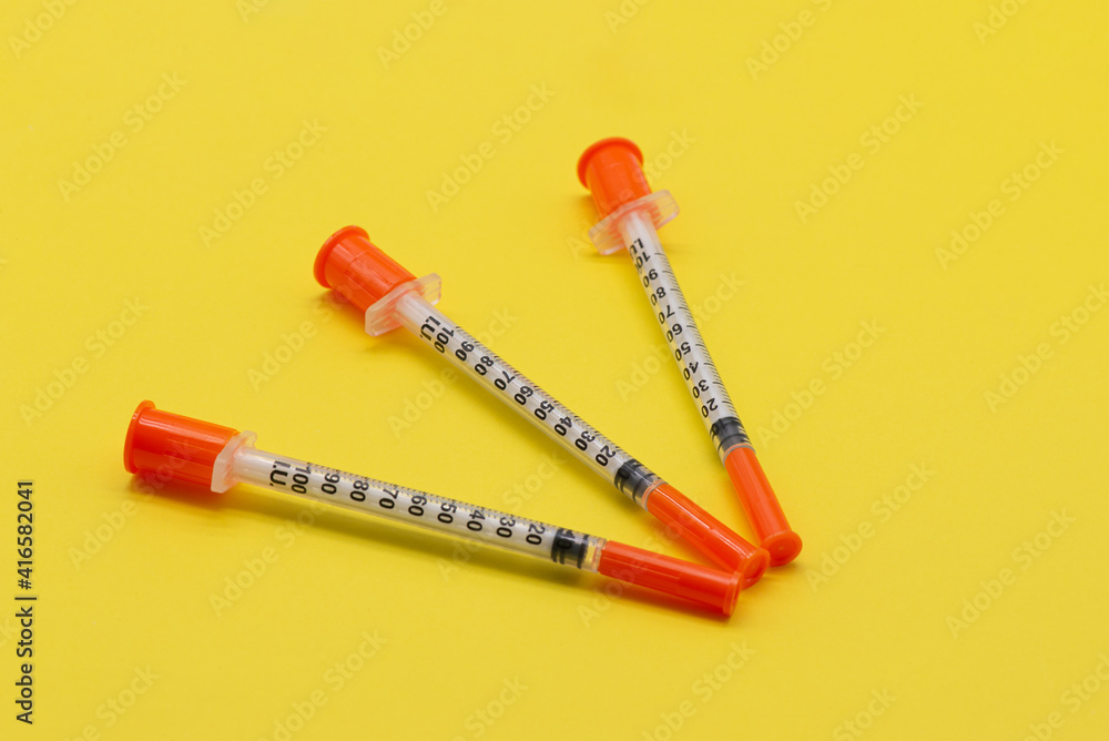 Insulin syringe on a yellow background
