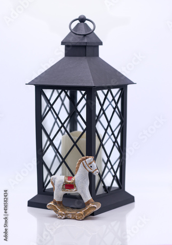 Obraz na płótnie Glass lamp with a candle inside and toy clay horse on a white background w salonie