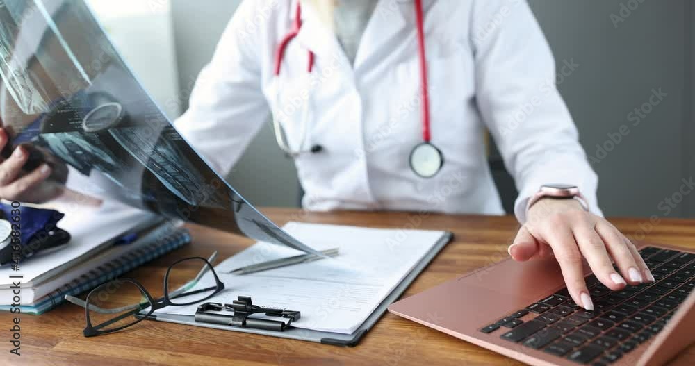 Doctor examining an x-ray at work table 4k movie. Snapshot of lungs with coronavirus infection concept Doctor examining an x-ray at work table 4k movie. Snapshot of lungs with coronavirus infection concept