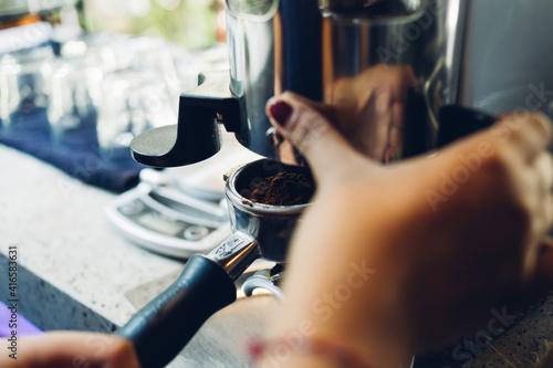 Close-up of espresso pouring from coffee machine. Professional coffee brewing. Coffee extraction from professional coffee machine with bottomless filter.