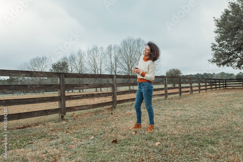 Portrait of young woman Resting near wooden fence during walk in countryside