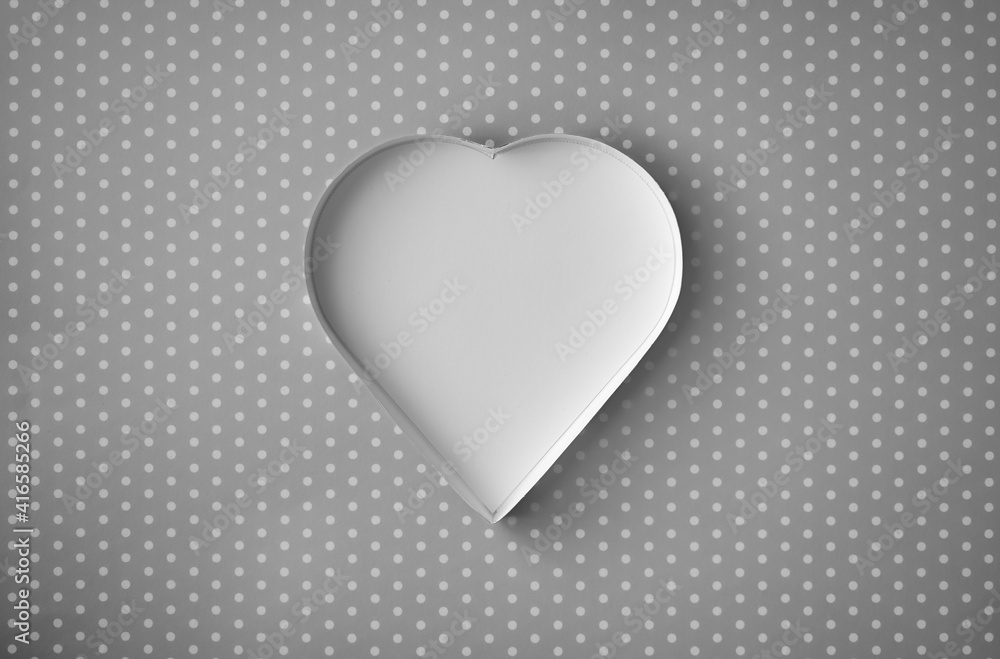 An empty, white heart-shaped box on a patterned grey background. An empty, white heart-shaped box on a patterned grey background.