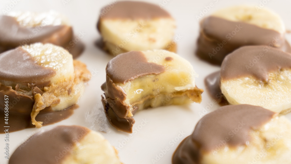 Sliced bananas in chocolate icing on a light background Sliced bananas in chocolate icing on a light background