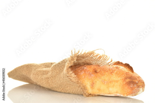 One freshly baked French baguette on jute fabric  close-up  isolated on white.