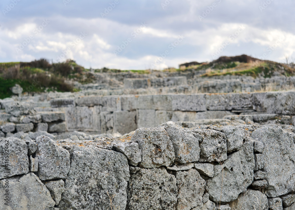 edge of the weathered wall of ancient ruins on a blurred background