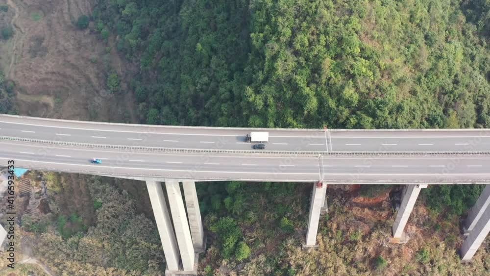 Tracking shot of a car driving on a highway overpass in the mountains of China