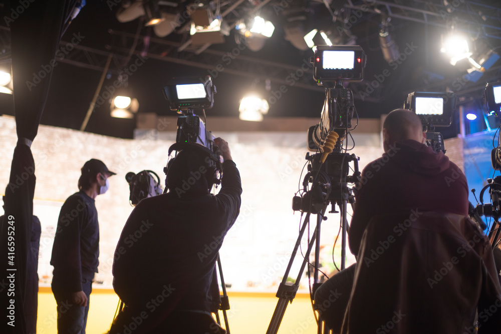masked cameraman is filming a television show in the studio. masked cameraman is filming a television show in the studio.