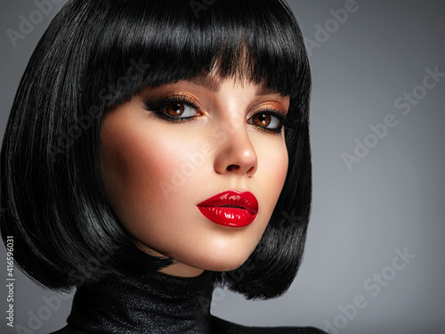 Fototapeta Beautiful brunette girl with red lips and black bob hairstyle