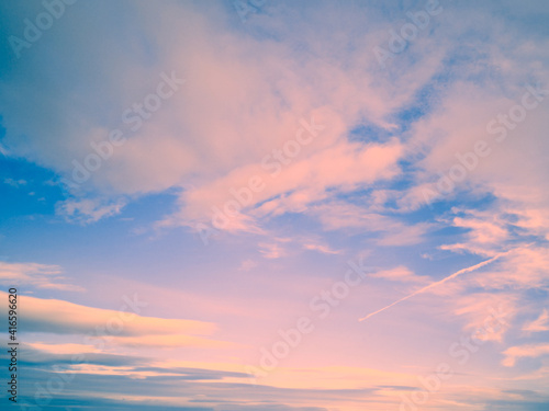 Wide blue pinkish sunset sky colorful clouds stretching away on beautiful sunny evening.Horizontal banner air texture abstract backdrop for text blog design agency website pattern model.Copy space
