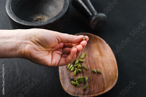 A woman holds a cardamom seeds in her hand