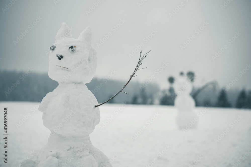 Schneemann in Winterlandschaft mit spielenden Kindern Schneemann in Winterlandschaft mit spielenden Kindern