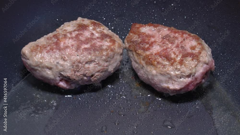 Cooking lunch or dinner concept. Two steaks are fried in a hot skillet. Cooking lunch or dinner concept. Two steaks are fried in a hot skillet.