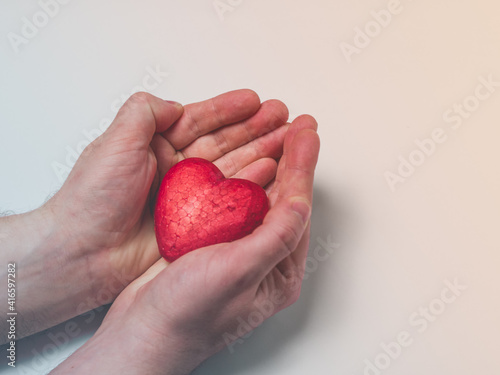 Fototapeta Naklejka Na Ścianę i Meble -  Man holding a red heart, health insurance, donation charity concept, world health day, world heart day, heart care, all lives matter concept