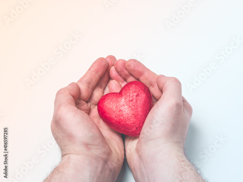 Man holding a red heart, health insurance, donation charity concept, world health day, world heart day, heart care, all lives matter concept